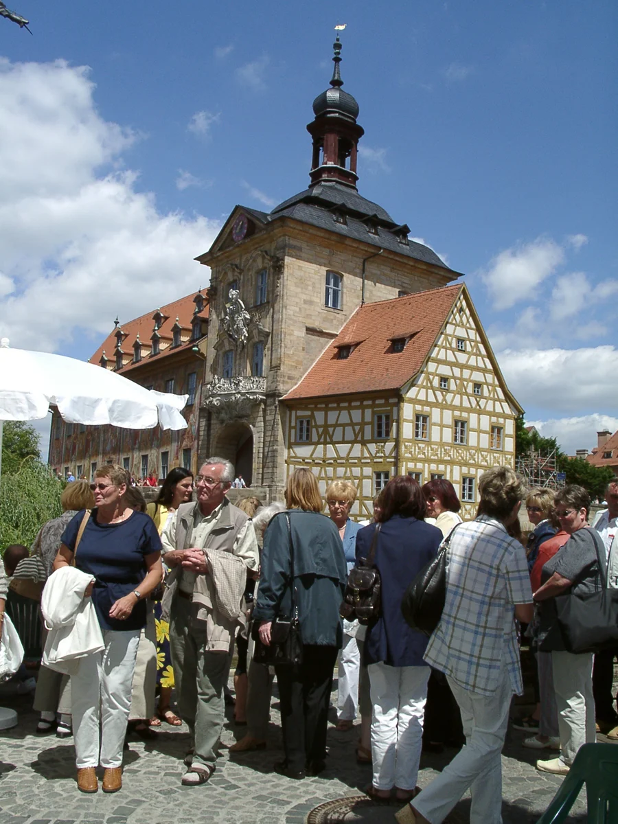 Passanten auf dem Geyerswörthsteg mit altem Rathaus in Bamberg im Hintergrund 