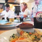 In einem würzigen Essig-Zwiebel-Sud gekochte Bratwürste.