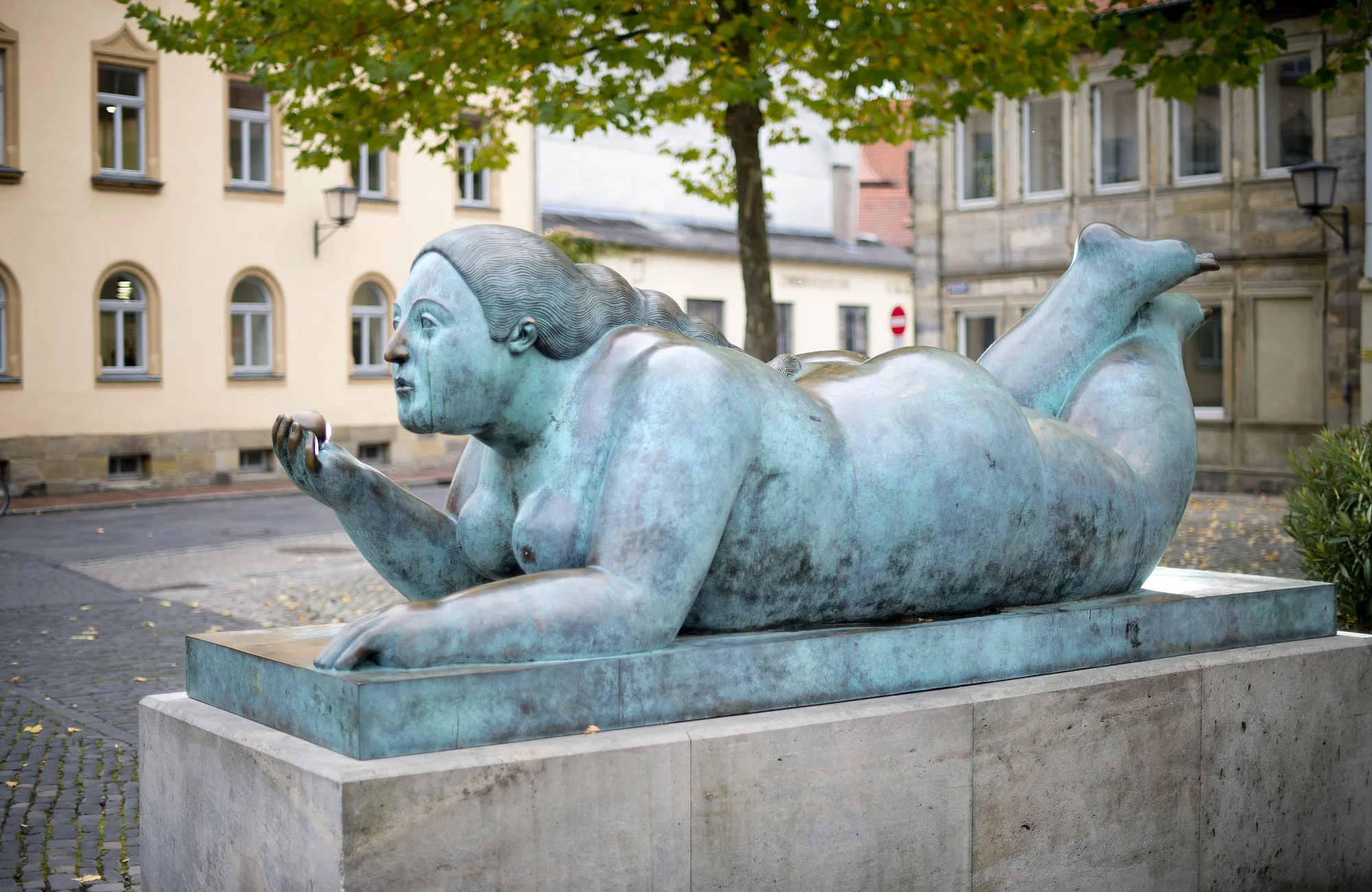 Von den Bambergern liebevoll „Dicke Frau“ oder „Blunnzn“ genannt, ist die Skulptur „Liegende mit Frucht“ des kolumbianischen Künstlers Fernando Botero ein markantes Kunstwerk in Bamberg.