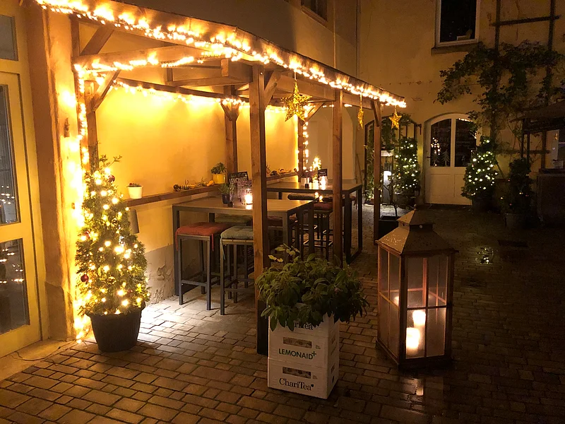 Foto des Außenbereichs des Café Leander Bamberg in weihnachtlicher Beleuchtung.
