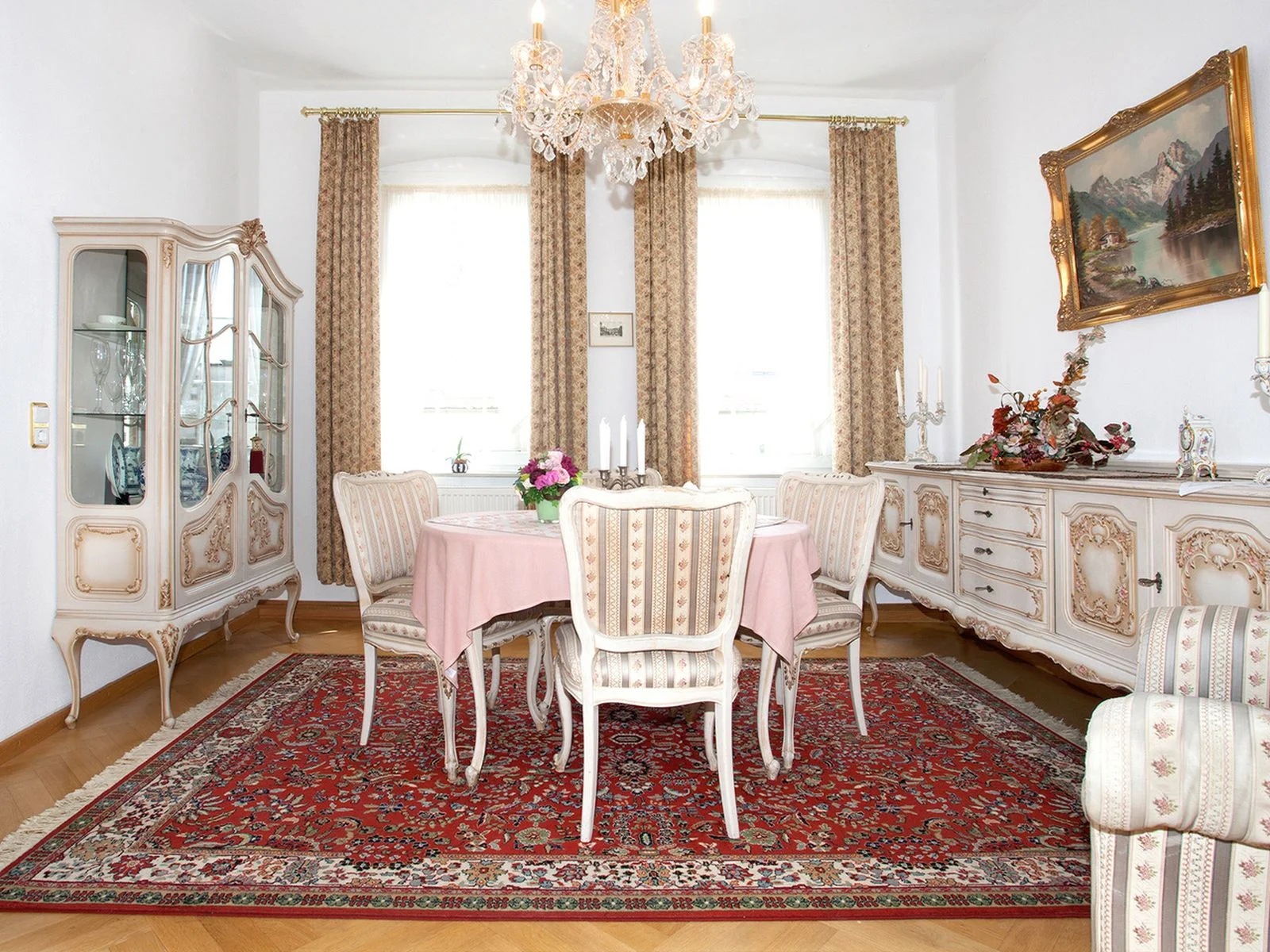 Elegantes Esszimmer mit großem Tisch, stilvollen Möbeln und Kronleuchter – ideal für entspannte Abende