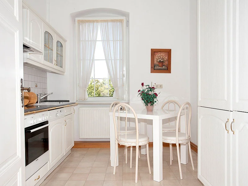 Helle, gepflegte Küche der Ferienwohnung Hideaway Bamberg mit Essplatz am Fenster und voll ausgestatteter Küchenzeile