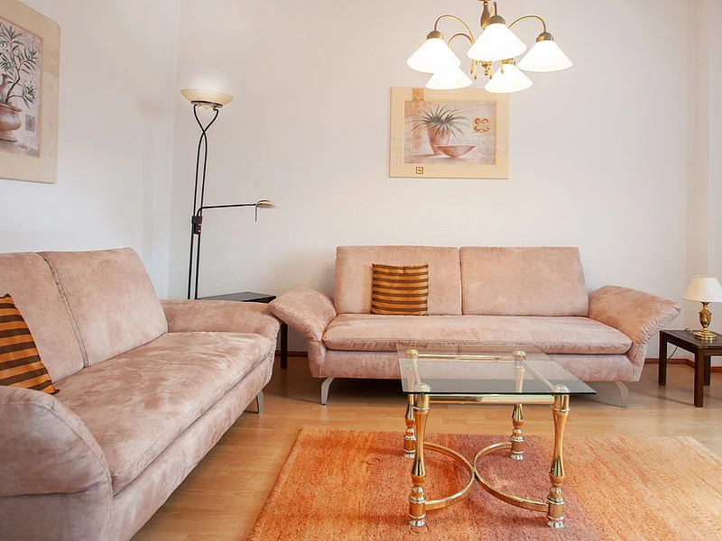 Gemütliches Wohnzimmer mit komfortablen Sofas, viel Tageslicht und stilvoller Einrichtung in ruhiger  Atmosphäre