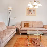 Gemütliches Wohnzimmer mit komfortablen Sofas, viel Tageslicht und stilvoller Einrichtung in ruhiger  Atmosphäre