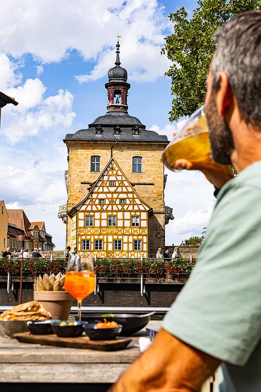 Essen mit Blick auf das Alte Rathaus Mit einem atembraubenden Blick auf das Bamberger Rathaus kann auf der Terrasse des Bamberger Lokals Henrii ein köstliches Menü genossen werden.